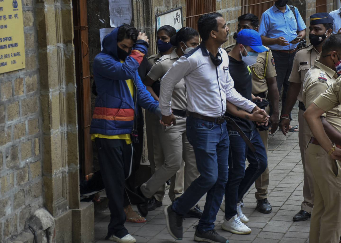 Bollywood actor Shah Rukh Khan’s son Aryan Khan, is escorted by law enforcement officials outside the Narcotics Control Bureau. AP