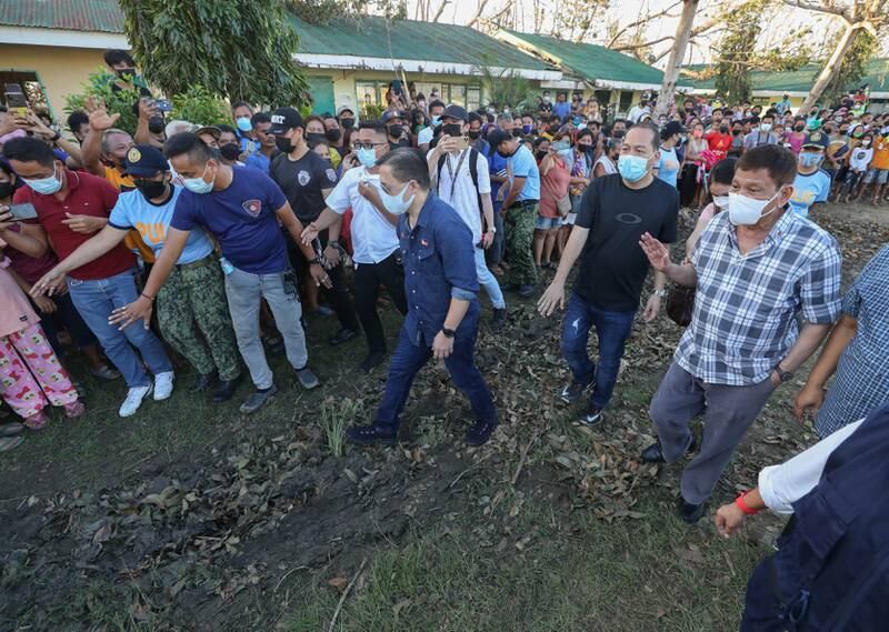 President Rodrigo Duterte, right, and Senator Bong Go, centre, with villagers during an inspection of the typhoon-hit island of Bohol, the Philippines. EPA