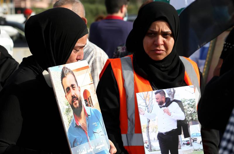 Family members of August 4 Beirut blast victims carry portraits of the deceased relatives, during a protest at the scene of the explosion, on May 4 2021. EPA