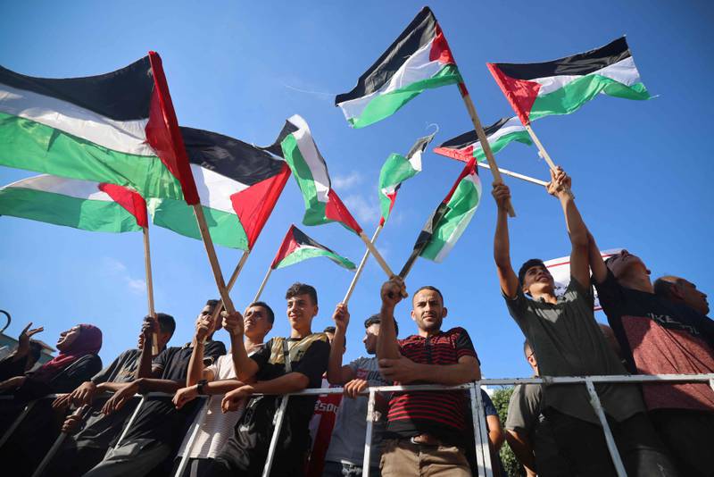 In Gaza City, Palestinian demonstrators wave their national flag as they gather to protest against the visit by US President Joe Biden to Israel. AFP