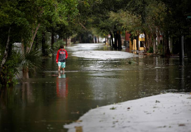 A boy wades through water on a flooded street as Ian bears down on Charleston. Reuters