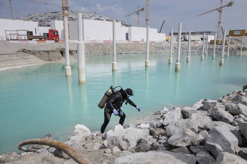 ABU DHABI, UNITED ARAB EMIRATES, Mar. 25, 2015:  
A diver, Neerag Kumar, 27, who has been working as diver for Marine Divers Marine Contractors for 3 years, emerges from the sea water while he works on installing a marine piles around the Louvre Abu Dhabi on Wednesday, Mar. 25, 2015, at the gallery's location on Saadiyat Island. There will be 279 piles, each 7 meters tall, some for boat navigation, most for aesthetic effect. As the work on Louvre Abu Dhabi progresses into its next stages, the marine works, which prepare the immediate surroundings of the gallery for future flooding with sea water, continue on dry land as well as underwater with the help of construction divers. (Silvia Razgova / The National)  (Usage: undated, restricted, Section: NA, Reporter: Nick Leech) *** Local Caption ***  SR-150325-LAD0314.jpg