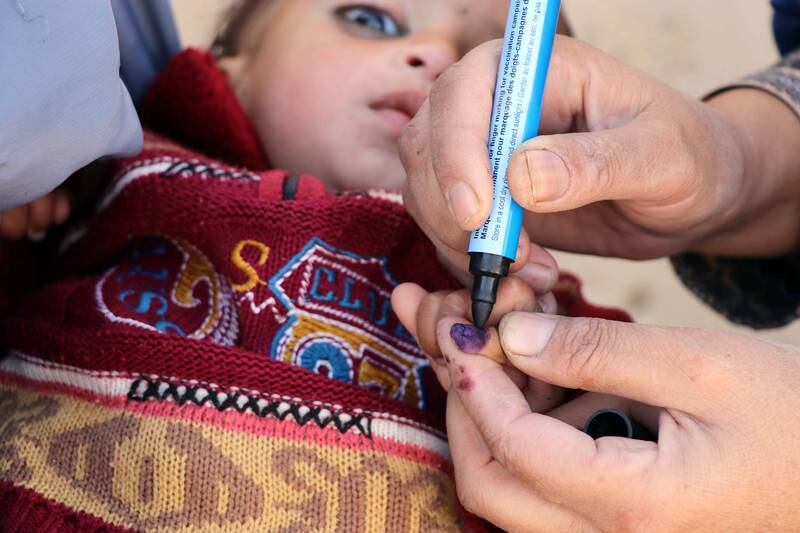 A health worker marks thumb of a child who received the polio vaccine in the southern Afghan city of Kandahar. Photo: EPA