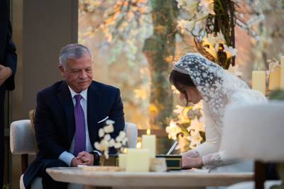 King Abdullah looks on as Princess Iman signs her marriage certificate. AFP