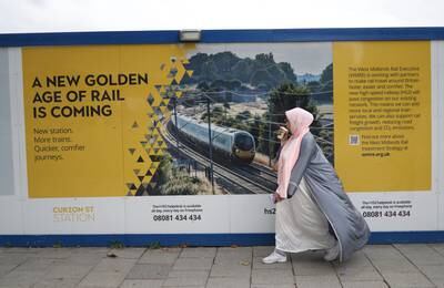 A woman walks past advertising hoarding for the HS2 high-speed rail link in Birmingham, England on Wednesday. The project, originally announced in 2009, is behind schedule and over budget. EPA