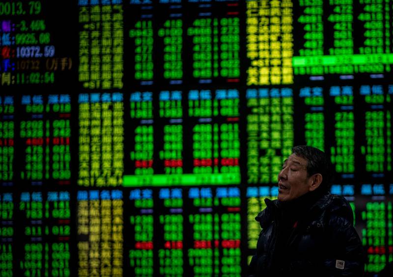 An investor reacts while keeping an eye on stock price movements shown on a screen at a securities company in Shanghai on February 9, 2018. 
Shanghai stocks plunged more than 5 percent by late morning on February 9 in the wake of renewed gloom on Wall Street and European markets. / AFP PHOTO / Johannes EISELE