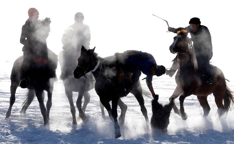 Horsemen take part in the traditional Central Asian sport of Kok-Boru in a village in Kyrgyzstan. Kok-boru is a game in which horsemen grab a goat carcass and try to win points by putting it in the opposing team's goal. EPA