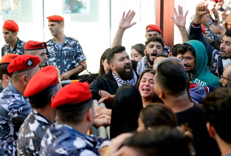 A Lebanese woman argues with security forces as she stands surrounded by protesters. AFP