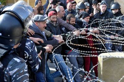 Anti-government protesters remove barbed wires at the entrance leading to the Lebanese Parliament building to protest Parliament meeting in downtown Beirut.  EPA