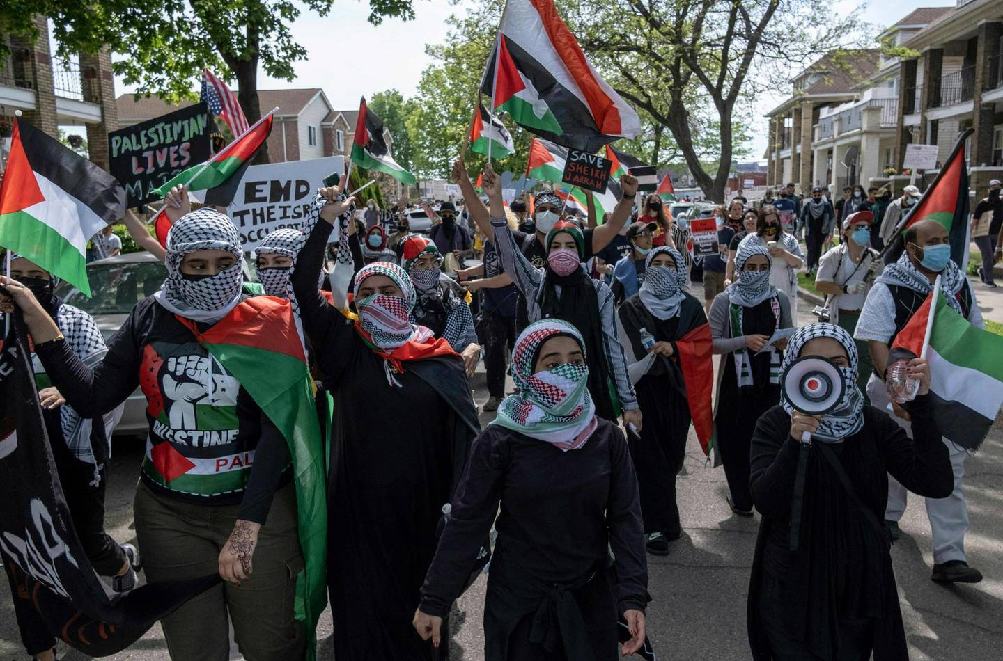 Protesters march through neighborhoods near a Ford Motor Company plant in Dearborn, Michigan on May 18, 2021, where US President Joe Biden is touring, to protest the Biden's continued support for Benjamin Netanyahu's administration, and the on going Israeli army actions in Gaza, and the forced removal of Palestinian families in Sheikh Jarrah in East Jerusalem.  US President Joe Biden, having resisted joining other world leaders and much of his own Democratic party in calling for an immediate end to hostilities, told Netanyahu Monday night he backs a ceasefire, but stopped short of demanding a truce. / AFP / SETH HERALD

