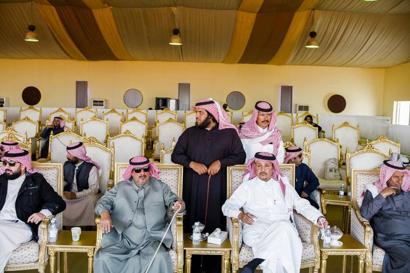 Camel owners are watching their camel herds being judgeg by jury during a beauty contest.