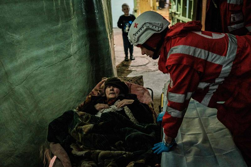 A member of the Ukrainian Red Cross talks to an internally displaced 92-year-old woman before taking her to an ambulance in a bunker at a factory in Severodonetsk, eastern Ukraine. AFP
