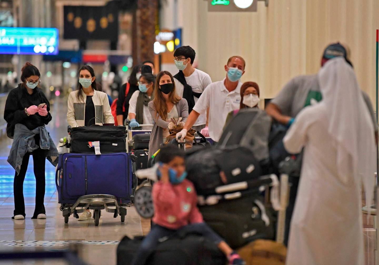 Passengers from an Emirates Airlines flight from London line up before being checked by health workers at Dubai International Airport on May 8, 2020 amid the coronavirus Covid-19 pandemic.





   / AFP / Karim SAHIB
