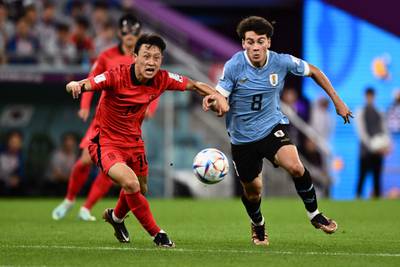 South Korea's midfielder Lee Jae-sung fights for the ball with Uruguay's Facundo Pellistri. AFP