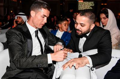 Juventus' Portuguese forward Cristiano Ronaldo signs an autograph for a fan during the 10th edition of the Dubai Globe Soccer Awards in Dubai. AFP