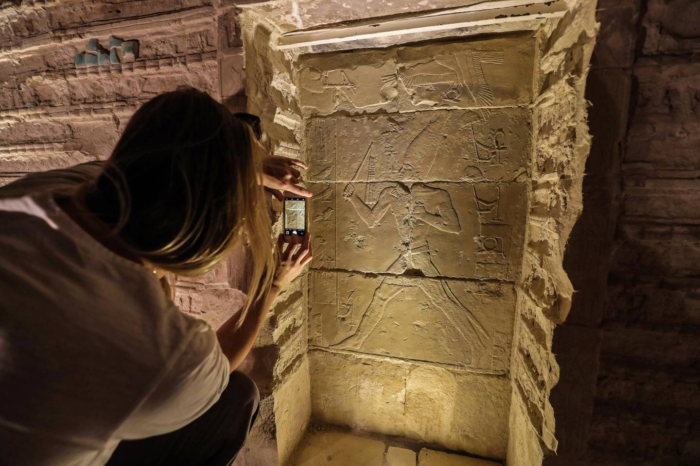 A tourist takes a picture of a relief depicting a pharaoh inside the step pyramid of Djoser in Egypt's Saqqara necropolis, south of the capital Cairo, on March 5, 2020. - Egyptian authorities inaugurated the famed step pyramid of Djoser,one of the earliest built in the country's ancient history, after years of renovation. The 4,700-year-old structure is nestled south of Cairo in the ancient capital of Memphis, a UNESCO World Heritage site, home to some of Egypt's most fascinating monuments. Renovation works started in 2006 but was interrupted in 2011 and 2012 for "security reasons" due to turmoil caused by a popular uprising that toppled late president Hosni Mubarak. (Photo by Mohamed el-Shahed / AFP)