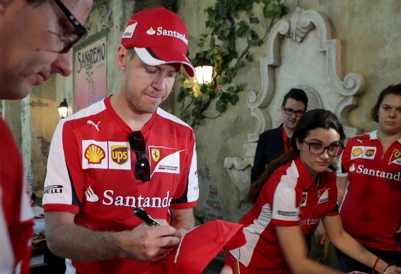 ABU DHABI - UNITED ARAB EMIRATES - 26NOV2015 - Ferrari champion, Sebastian Vettel signing the cap for fans on the occasion of Ferrari World's 5th Anniversary Celebrations yesterday in Abu Dhabi. Ravindranath K / The National (for News)
ID: 42084 *** Local Caption ***  RK2611-F1drivers03.jpg