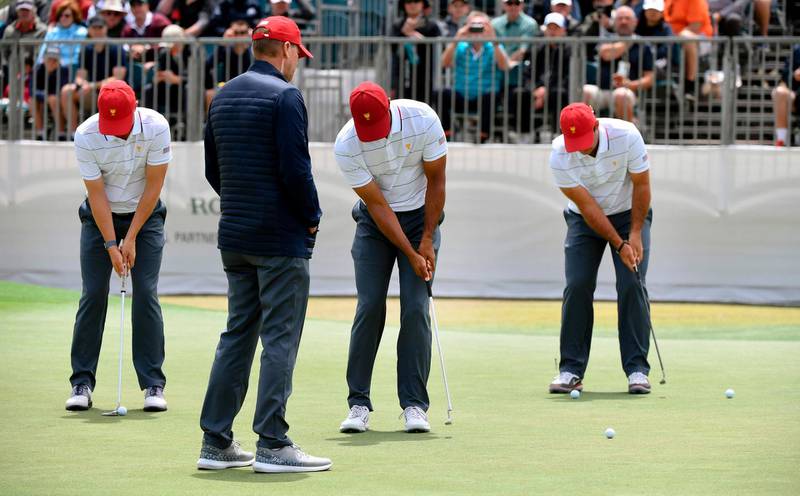 US team vice captain Steve Stricker (2nd L) watches his players practice putting. AFP