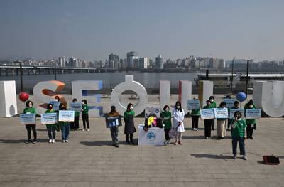 South Korean environmental activists hold placards reading ‘I will protect the sea from microplastics’ during a campaign to mark World Water Day at a park along the Han River in Seoul. AFP