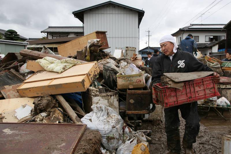 A man removes muddy items from the flood-damaged homes in Nagano, after Typhoon Hagibis hit Japan on October 12 unleashing high winds, torrential rain and triggered landslides and catastrophic flooding. Rescuers in Japan worked into a third day in an increasingly desperate search for survivors of a powerful typhoon that killed nearly 70 people and caused widespread destruction. AFP