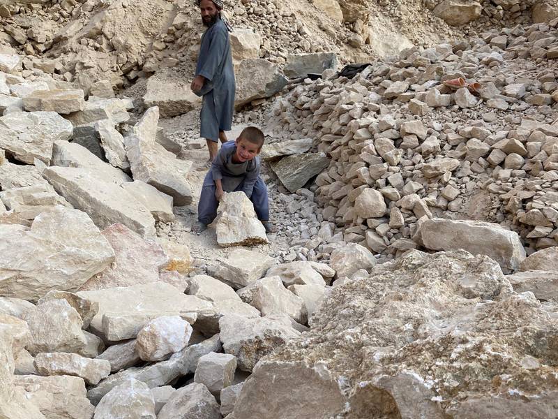 Mohammad Naem watches as his younger son Razmad, 4, carries a rock from the mine. Hikmat Noori for The National