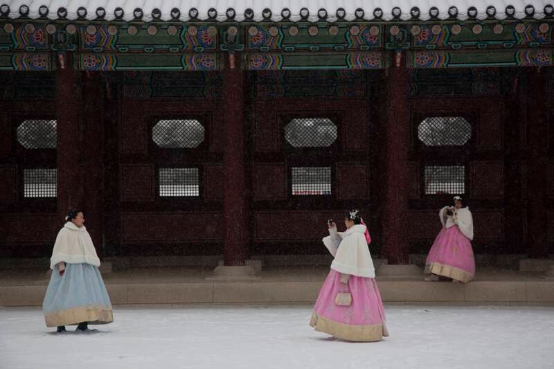 Vietnamese tourists wearing South Korean traditional clothes take a pictures outside Gyeongbokgung Palace in Seoul, where temperatures reached minus 7.7°C. EPA