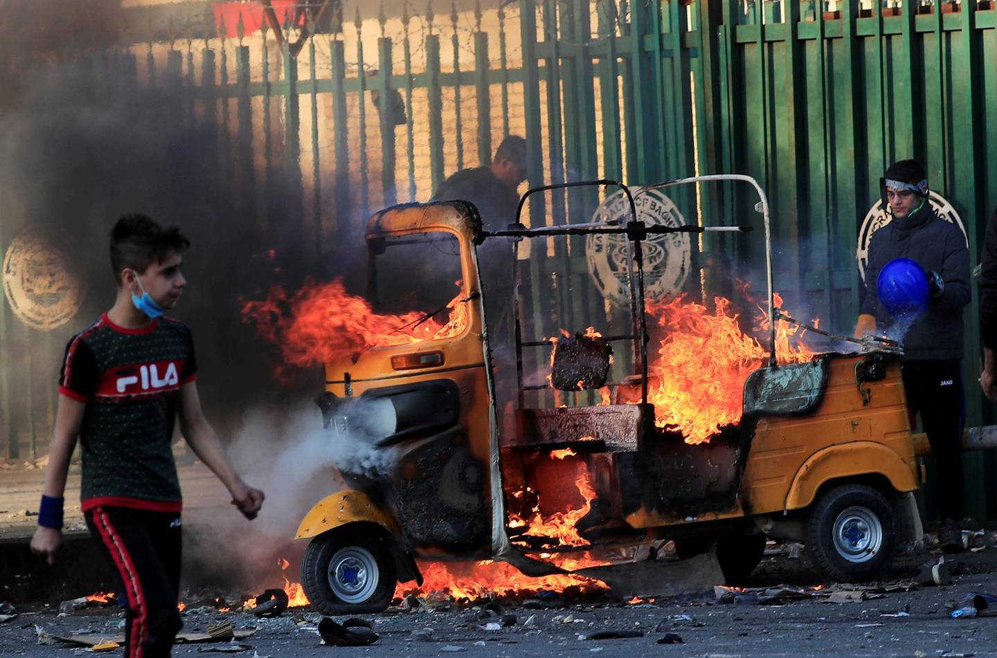 FILE PHOTO: A tuk-tuk is burning after it was set on fire by Iraqi security forces during ongoing anti-government protests in Baghdad, Iraq January 31, 2020. REUTERS/Thaier al-Sudani/File Photo