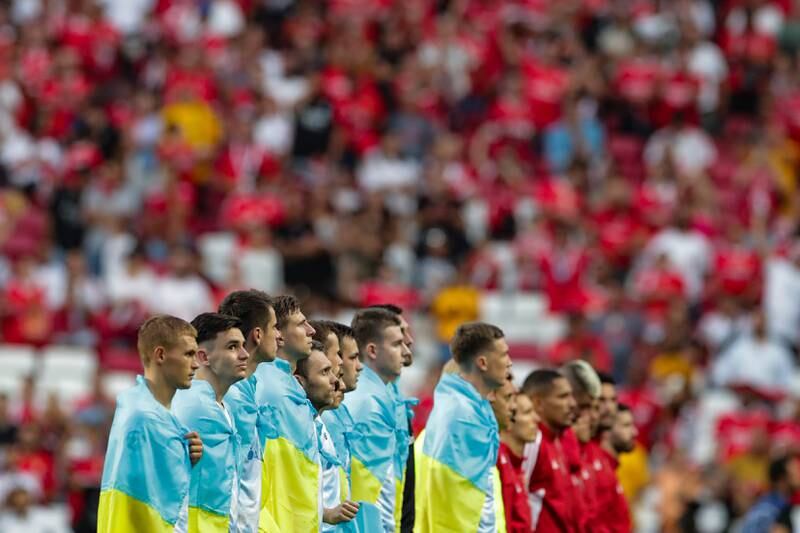 Dynamo Kyiv players wrapped in Ukrainian national flags before their second-leg Champions League play-off match against Benfica in Lisbon. EPA