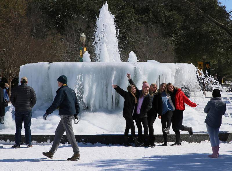 Baylor University students enjoy their snow day without classes while posing near a fountain on campus in Waco, Texas. AP