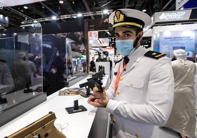 Abu Dhabi, United Arab Emirates, February 21, 2021.  Idex 2021, the first major in-person exhibition held in Abu Dhabi since the start of the Covid-19 pandemic, opened its doors to delegates on Sunday morning.  --Saeed Al Mansoori looks at a GLOCK 9mm. pistol.Victor Besa / The NationalSection:  NAReporter:  John Dennehy
