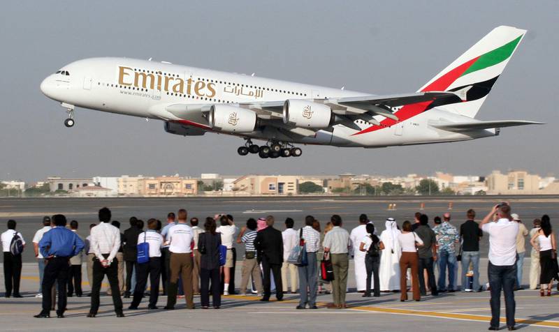 Visitors watch an Airbus A380, sporting the colors of air carrier Emirates, take off during the Dubai Air Show on November 22, 2005.  AFP