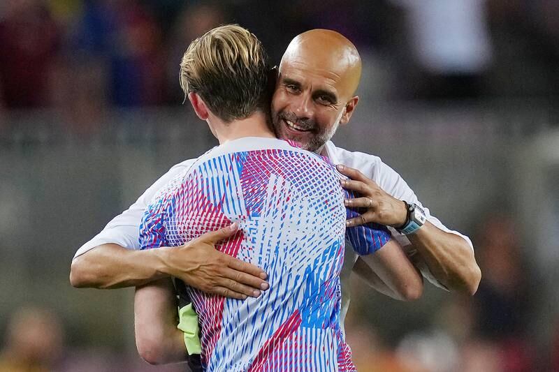 Pep Guardiola, manager of Manchester City, speaks to Frenkie de Jong of Barcelona after the friendly match. Getty Images