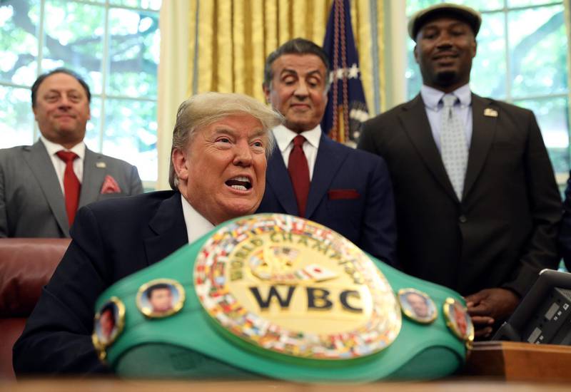 With actor Sylvester Stallone (2nd R) and boxer Lennox Lewis (R) behind him, U.S. President Donald Trump speaks before signing a pardon for the late Jack Johnson, the first black heavyweight boxing champion, at the White House in Washington, U.S., May 24, 2018. REUTERS/Kevin Lamarque