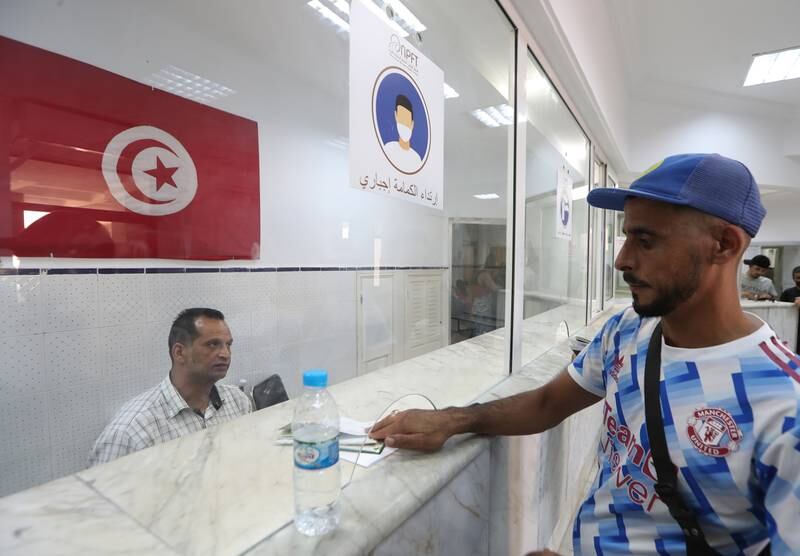 A Tunisian official checks passports at the Malloula border post near Tabarka. EPA