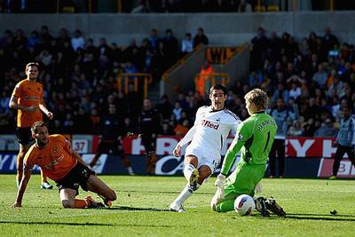 Danny Graham, the Swansea striker, centre, manages to guide this shot past the rushing Wolves goalkeeper Wayne Hennessey during their 2-2 draw at Molineux.

Laurence Griffiths / Getty Images