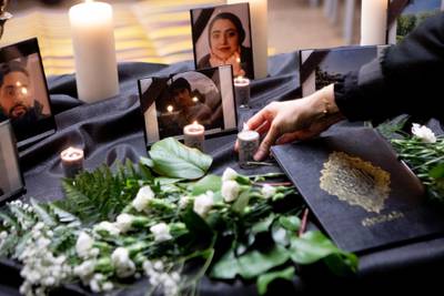 A candle is placed on a table bearing photos of some of the victims of a Ukraine International Airlines passenger flight that crashed after takeoff near Tehran, Iran.  AP