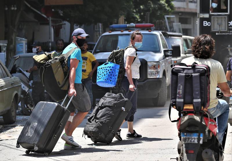 People walk with their belongings in the area of Mar Mikhael and Gemayzeh.  EPA