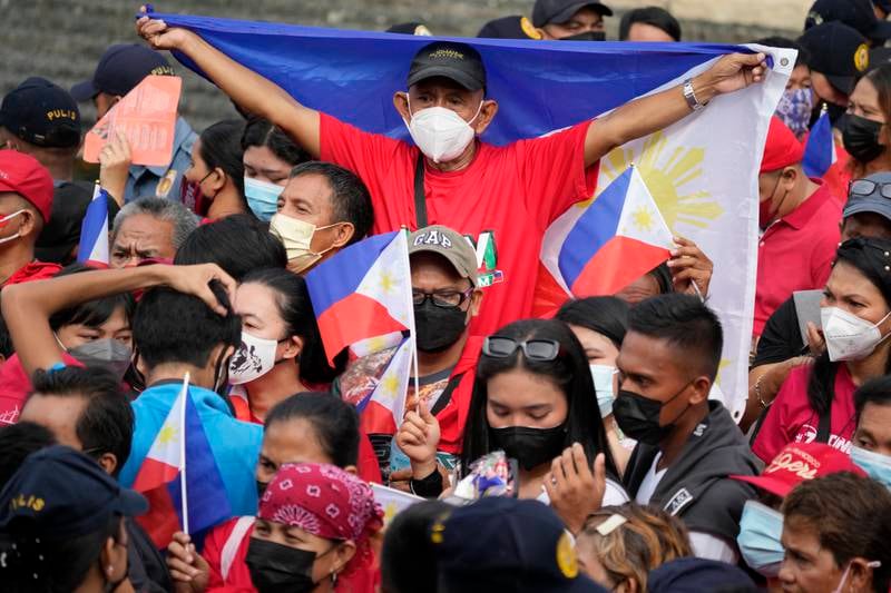 A supporter holds the national flag. Mr Marcos Jr received more than 31 million votes and incoming vice president Sara Duterte more than 32 million of the more than 55 million votes cast in the May 9 election. AP