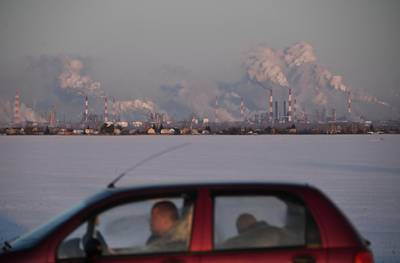 A car drives past the Gazprom Neft's oil refinery in Omsk, Russia.  Reuters