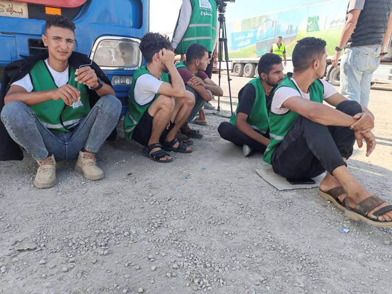 Egyptian volunteers sit on the ground next to trucks as aid groups wait for the reopening of the crossing. Reuters
