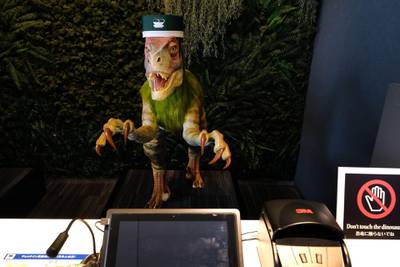 A robot dinosaur wearing a bellboy hat welcomes guests from the front desk at the Henn-na Hotel.  AFP