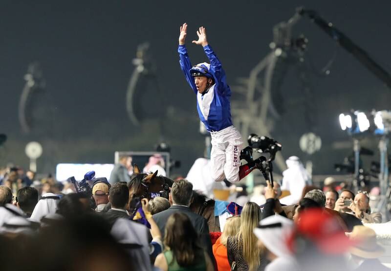 Frankie Dettori performs his classic flying dismount from his horse after winning the Dubai Turf. Chris Whiteoak / The National