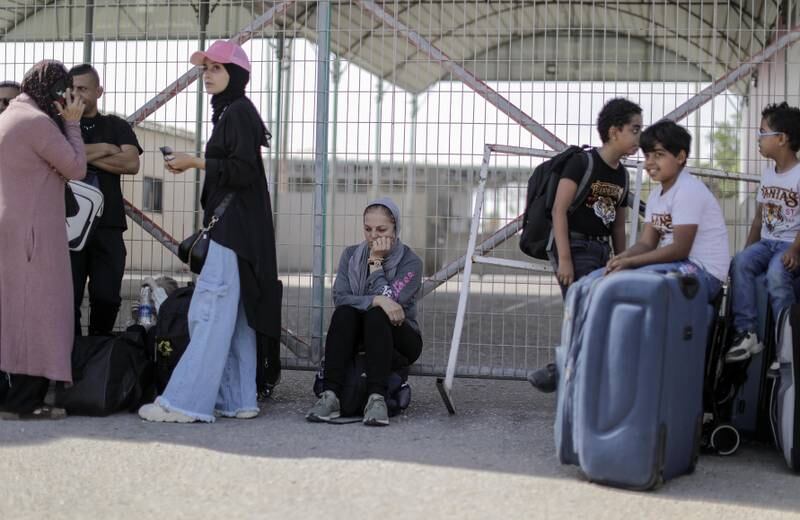 Palestinians with dual nationality wait to cross the Rafah border crossing into Egypt, on Saturday. EPA