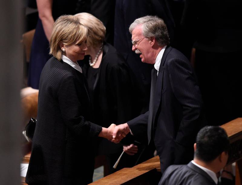 Former US First Lady shakes hands with National Security adviser John Bolton as they arrive at the memorial Service. AFP