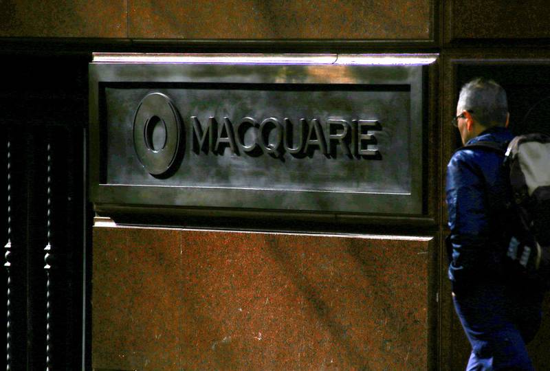 FILE PHOTO: A pedestrian walks past the logo of Australia's biggest investment bank Macquarie Group Ltd which adorns a wall on the outside of their Sydney office headquarters in central Sydney, Australia, July 18, 2017.  Picture taken July 18, 2017. REUTERS/David Gray/File Photo