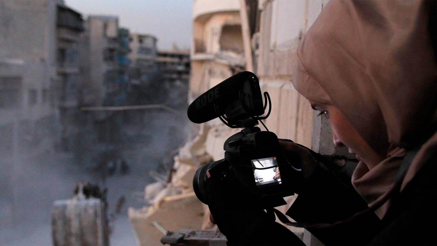 This image released by PBS shows Waad al-Kateab filming the ruins of a building destroyed by bombing in besieged east Aleppo in the Oscar-nominated documentary "For Sama." (PBS/Frontline via AP)