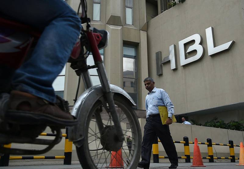 A Pakistani man walks past the Habib Bank Limited (HBL) building in Pakistan's port city of Karachi on August 29, 2017.
A Pakistani private bank is facing some 629 million dollars penalty in the United States over accusations of non compliance of financial standards and practices. Habib Bank Limited (HBL), one of the largest listed bank in Pakistan on August 28 told the Pakistan Stock Exchange (PSX) through a letter that it had decided to wind up its United State business. / AFP PHOTO / ASIF HASSAN
