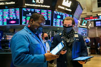 In this photo provided by the New York Stock Exchange, traders Thomas Lee, left, and Benjamin Tuchman work on the floor Friday, Nov. 20, 2020. U.S. stocks are pulling a bit lower in midday trading Friday as worries about the worsening pandemic weigh on rising optimism about a coming coronavirus vaccine. (Courtney Crow/New York Stock Exchange via AP)