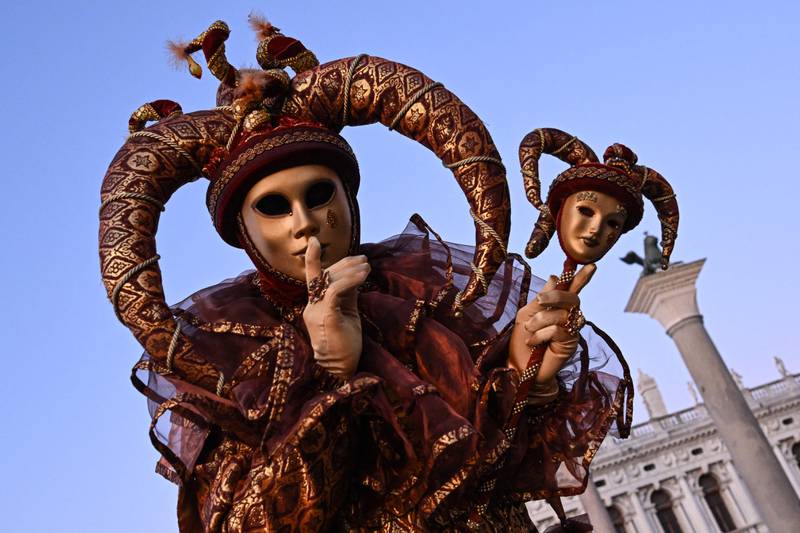 A masked reveller wearing traditional carnival costumes poses during the carnival in Venice on February 11, 2023.  (Photo by MIGUEL MEDINA  /  AFP)