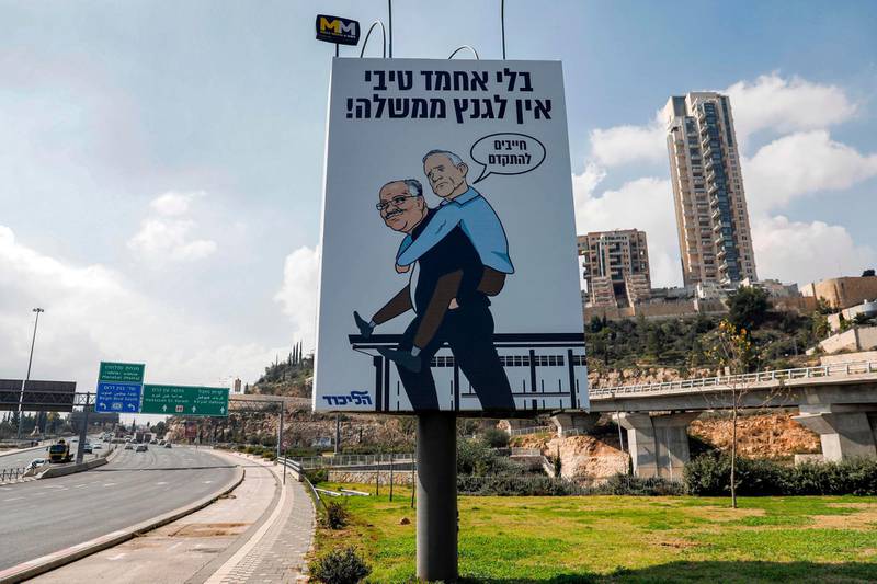 A Likud party campaign poster with a cartoon showing retired general Benny Gantz, the leader of the opposition Blue and White alliance, being carrier by Arab Movement for Change praty head Ahmad Tibi with a Hebrew caption saying "Gantz has no government without Tibi" and a speech bubble above Gantz with him saying "we must move forward". AFP